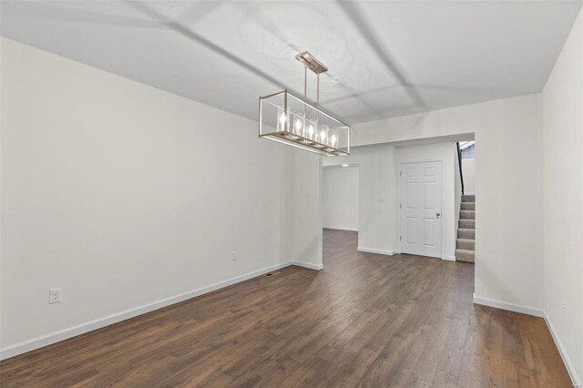 610 Tull Ct, Wentzville, MO 63385 - unfurnished dining area featuring dark wood-style floors, stairs, baseboards, and a chandelier
