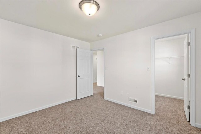 610 Tull Ct, Wentzville, MO 63385 - unfurnished bedroom featuring carpet, a spacious closet, a closet, and baseboards