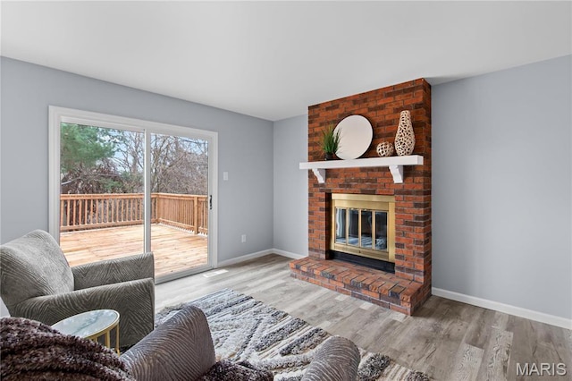 3524 Espace Ct, Florissant, MO 63034 - living area featuring a brick fireplace, wood finished floors, and baseboards