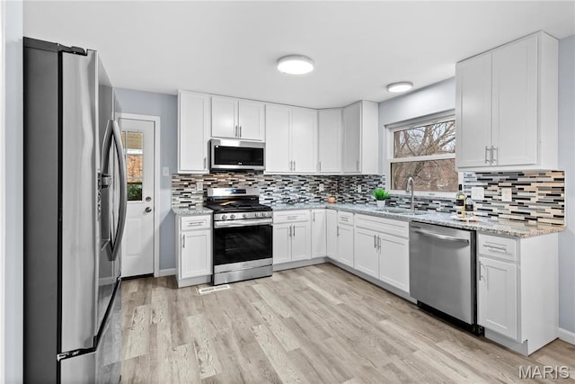 3524 Espace Ct, Florissant, MO 63034 - kitchen featuring stainless steel appliances, a sink, light wood-type flooring, and white cabinetry