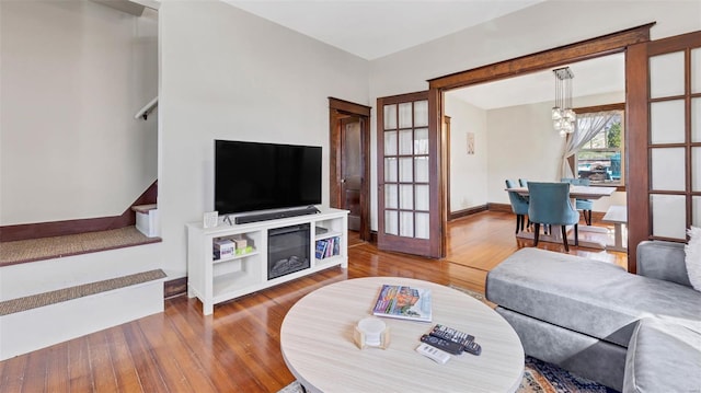 125 W 2nd St, Hermann, MO 65041 - living area with wood finished floors, a chandelier, baseboards, french doors, and stairway