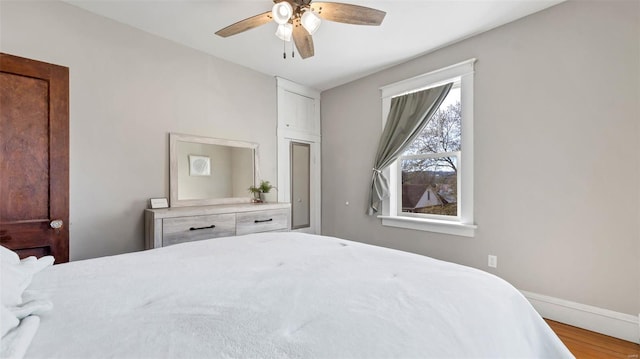 125 W 2nd St, Hermann, MO 65041 - bedroom featuring wood finished floors, baseboards, and a ceiling fan