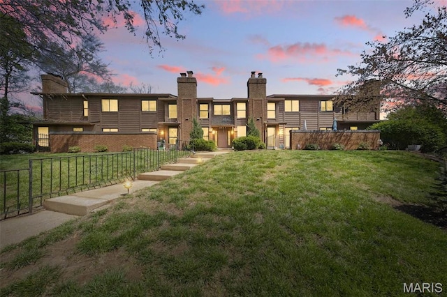 2037 Trailcrest Ln Unit 7, Saint Louis, MO 63122 - back of house at dusk featuring a chimney and brick siding