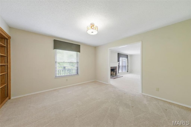2037 Trailcrest Ln Unit 7, Saint Louis, MO 63122 - empty room featuring healthy amount of natural light, carpet flooring, a fireplace with raised hearth, baseboards, and a textured ceiling