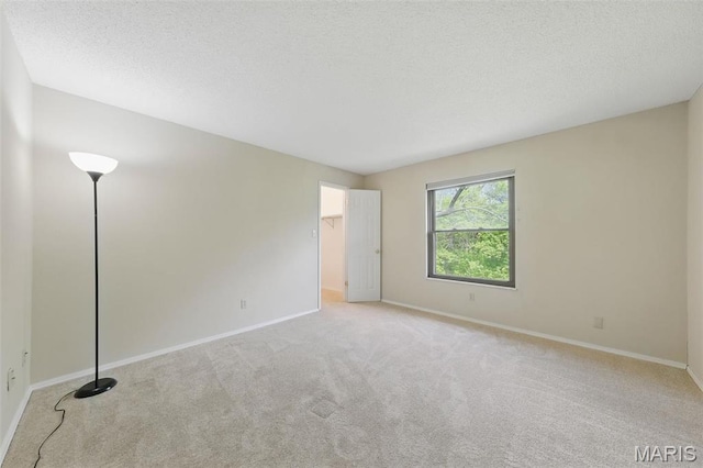 2037 Trailcrest Ln Unit 7, Saint Louis, MO 63122 - unfurnished bedroom with carpet floors, baseboards, a walk in closet, and a textured ceiling