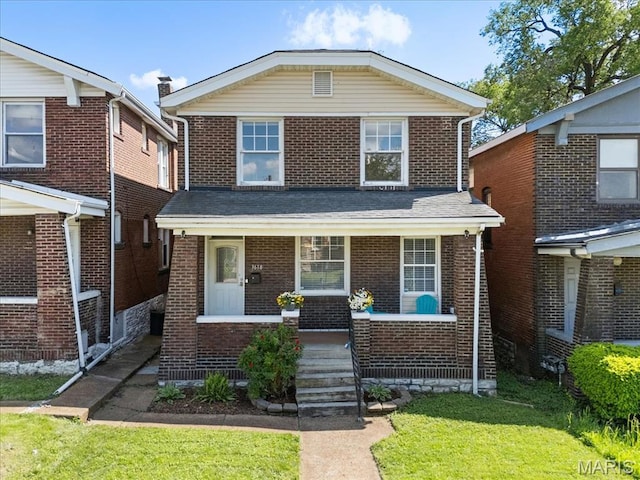 3618 Mcree Ave, Saint Louis, MO 63110 - view of front facade with a porch, brick siding, and a front lawn