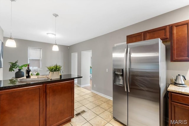 3618 Mcree Ave, Saint Louis, MO 63110 - kitchen with stainless steel fridge with ice dispenser, decorative light fixtures, light tile patterned flooring, and dark stone counters