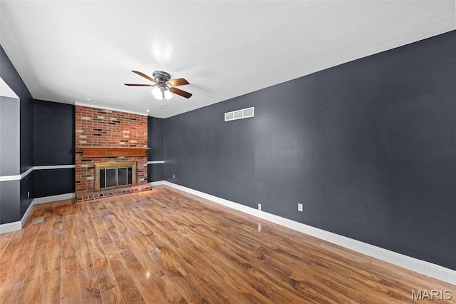 2915 Coram Dr, Saint Louis, MO 63129 - unfurnished living room featuring a ceiling fan, wood finished floors, baseboards, and a brick fireplace