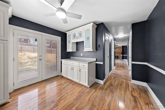 2915 Coram Dr, Saint Louis, MO 63129 - kitchen with french doors, white cabinetry, and light wood finished floors