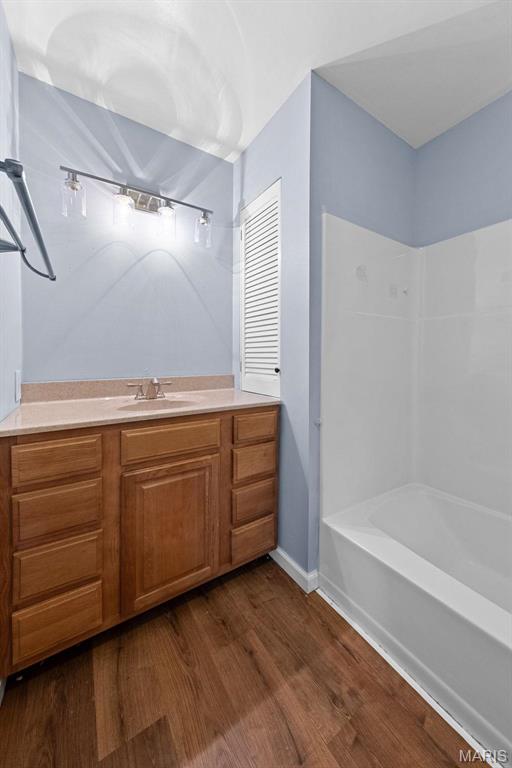 2915 Coram Dr, Saint Louis, MO 63129 - full bathroom with wood finished floors, washtub / shower combination, vanity, and baseboards