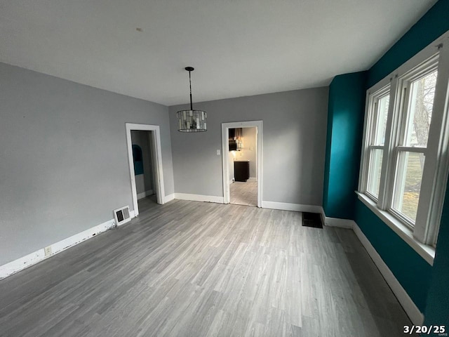 145 S 34th St, Belleville, IL 62226 - unfurnished dining area featuring wood finished floors, baseboards, and a chandelier