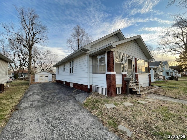 145 S 34th St, Belleville, IL 62226 - view of front of house with asphalt driveway, a garage, and an outbuilding