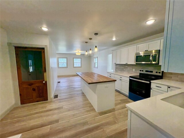 107 S Jackson St, Perryville, MO 63775 - kitchen with stainless steel appliances, butcher block counters, white cabinetry, tasteful backsplash, and light wood finished floors