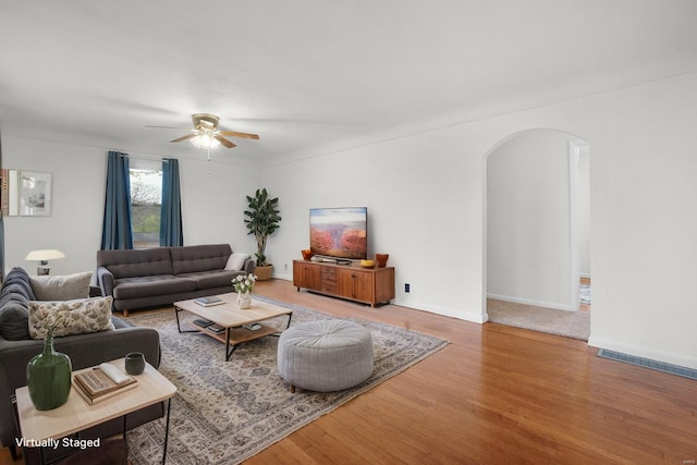 1163 Peace Valley Ln, Hermann, MO 65041 - living area with arched walkways, ceiling fan, and wood finished floors