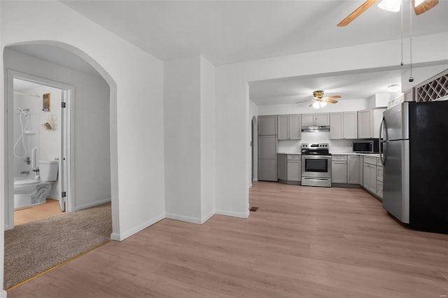 1163 Peace Valley Ln, Hermann, MO 65041 - kitchen featuring stainless steel appliances, a ceiling fan, gray cabinetry, and arched walkways