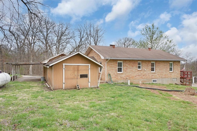 1163 Peace Valley Ln, Hermann, MO 65041 - back of house featuring a shed, brick siding, a yard, a carport, and an outdoor structure
