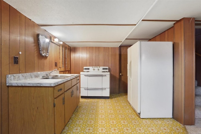 1163 Peace Valley Ln, Hermann, MO 65041 - kitchen with white appliances, a sink, wood walls, brown cabinetry, and light flooring
