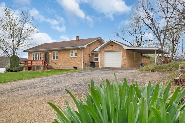 1163 Peace Valley Ln, Hermann, MO 65041 - ranch-style house with brick siding, dirt driveway, a chimney, a carport, and an attached garage