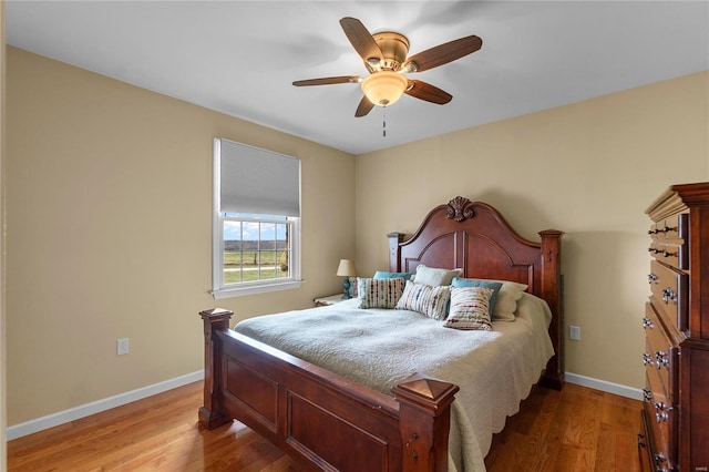 bedroom featuring baseboards, light wood-style flooring, and ceiling fan
