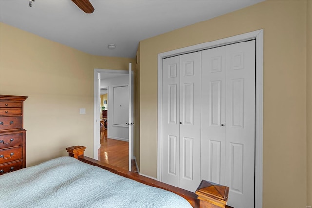 bedroom with a closet, wood finished floors, and ceiling fan