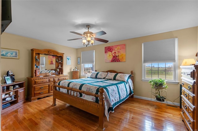 bedroom featuring light wood finished floors, baseboards, and a ceiling fan