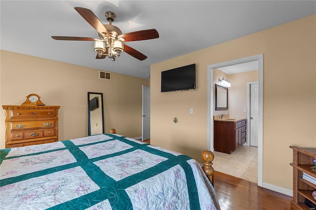 bedroom with a sink, light wood-style flooring, and ceiling fan