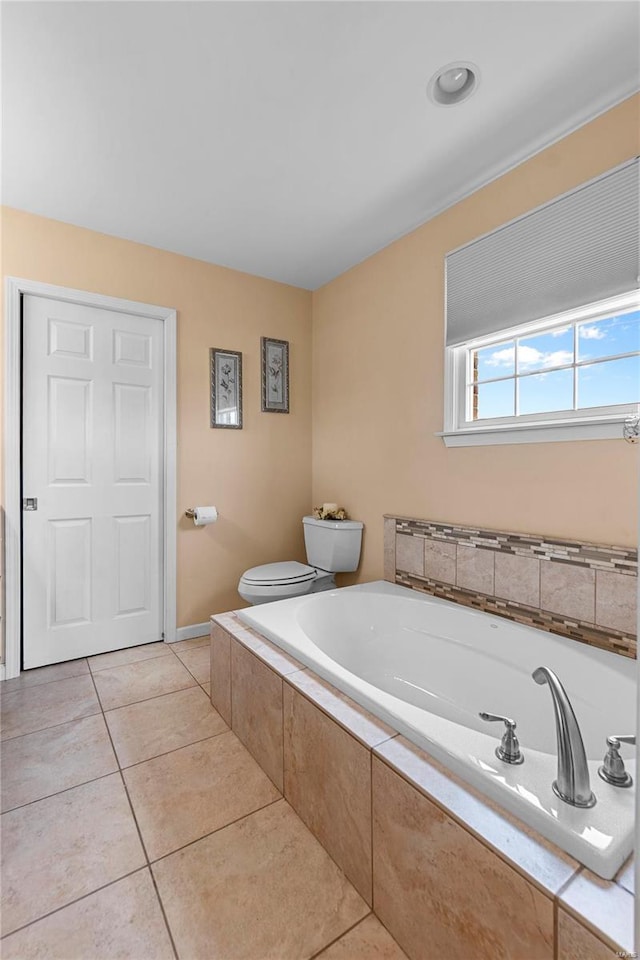 full bathroom featuring a bath, tile patterned floors, and toilet