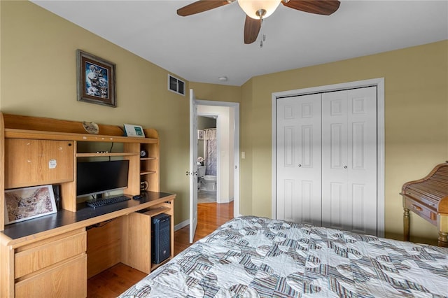 bedroom featuring a closet, wood finished floors, a desk, a ceiling fan, and baseboards