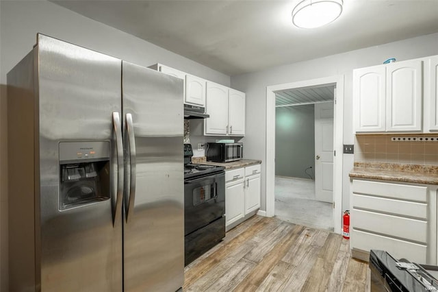 13 Wayne 357b, Piedmont, MO 63957 - kitchen featuring stainless steel appliances, under cabinet range hood, white cabinetry, light wood-type flooring, and backsplash