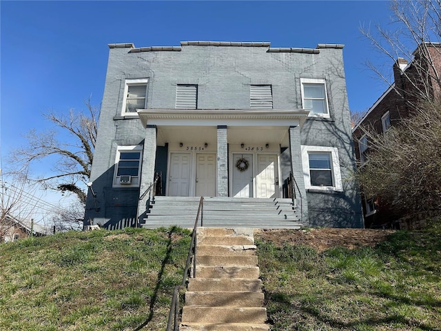 view of front of home with a porch, brick siding, and cooling unit