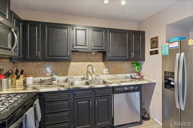 92 Waters Edge Ct Unit 15-2B, Four Seasons, MO 65049 - kitchen featuring appliances with stainless steel finishes, a sink, light countertops, decorative backsplash, and a textured ceiling