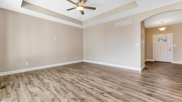 149 Haven Ridge Ct, Dardenne Prairie, MO 63368 - unfurnished room featuring a raised ceiling, arched walkways, ceiling fan, and wood finished floors