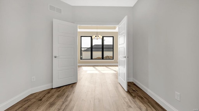 149 Haven Ridge Ct, Dardenne Prairie, MO 63368 - hall featuring a chandelier, wood finished floors, and baseboards