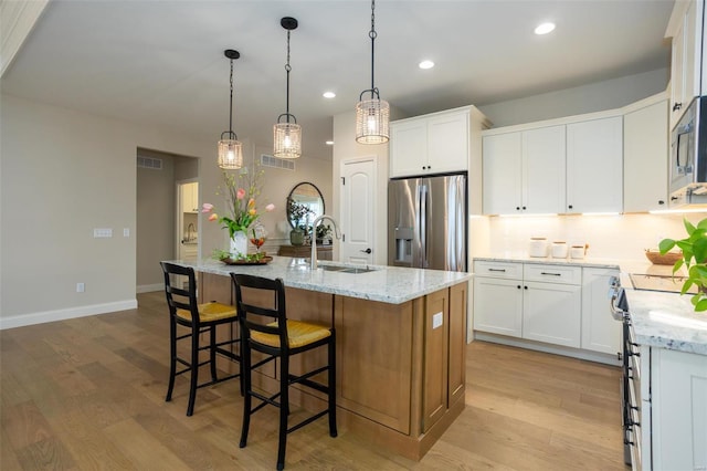 192 Santa Elena Dr, Wentzville, MO 63385 - kitchen featuring appliances with stainless steel finishes, a sink, backsplash, recessed lighting, and a kitchen island with sink