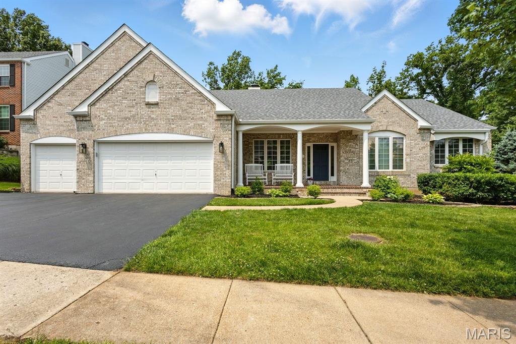 730 Mark Wesley Ln, Ballwin, MO 63021 - view of front facade with a porch, brick siding, asphalt driveway, and a garage