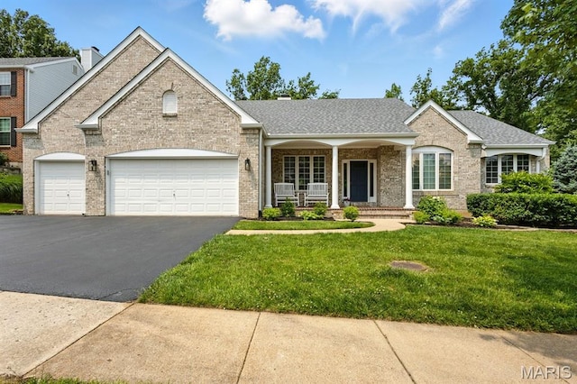 730 Mark Wesley Ln, Ballwin, MO 63021 - view of front facade with a porch, brick siding, asphalt driveway, and a garage