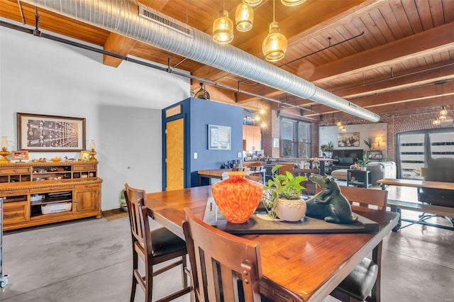 dining area with finished concrete flooring, beamed ceiling, and wooden ceiling