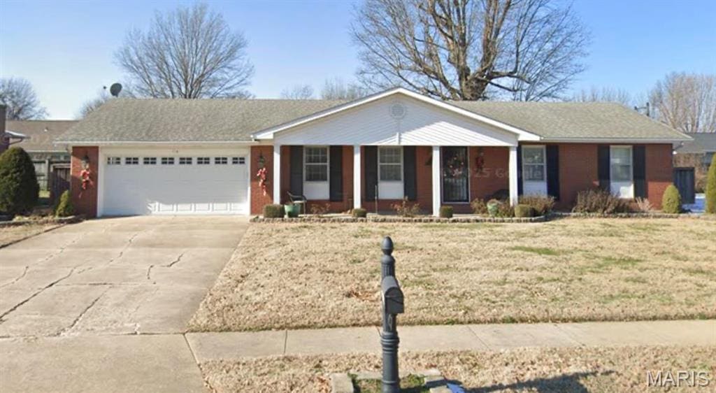 single story home with a garage, covered porch, driveway, and a front lawn
