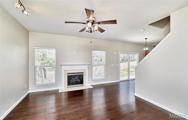 460 Fortress Ct, Saint Charles, MO 63303 - unfurnished living room featuring dark wood-style flooring, a high end fireplace, a ceiling fan, baseboards, and a chandelier