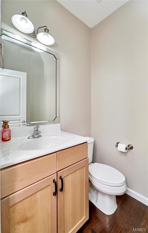 460 Fortress Ct, Saint Charles, MO 63303 - half bathroom featuring vanity, toilet, wood finished floors, and baseboards