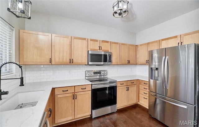 460 Fortress Ct, Saint Charles, MO 63303 - kitchen featuring appliances with stainless steel finishes, light brown cabinets, a sink, and light stone counters