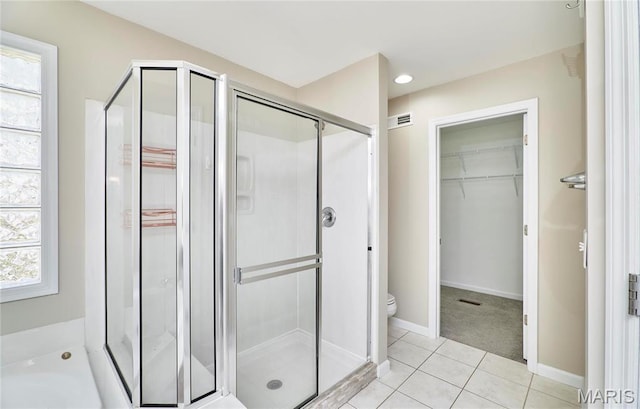 460 Fortress Ct, Saint Charles, MO 63303 - bathroom with a shower stall, a spacious closet, toilet, tile patterned floors, and baseboards
