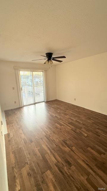 unfurnished room with dark wood finished floors, a ceiling fan, and a textured ceiling