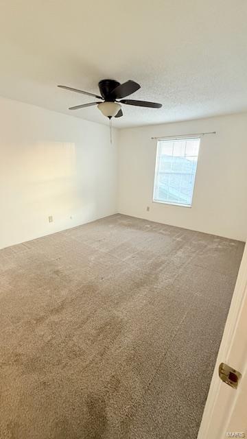 spare room featuring light carpet and a ceiling fan