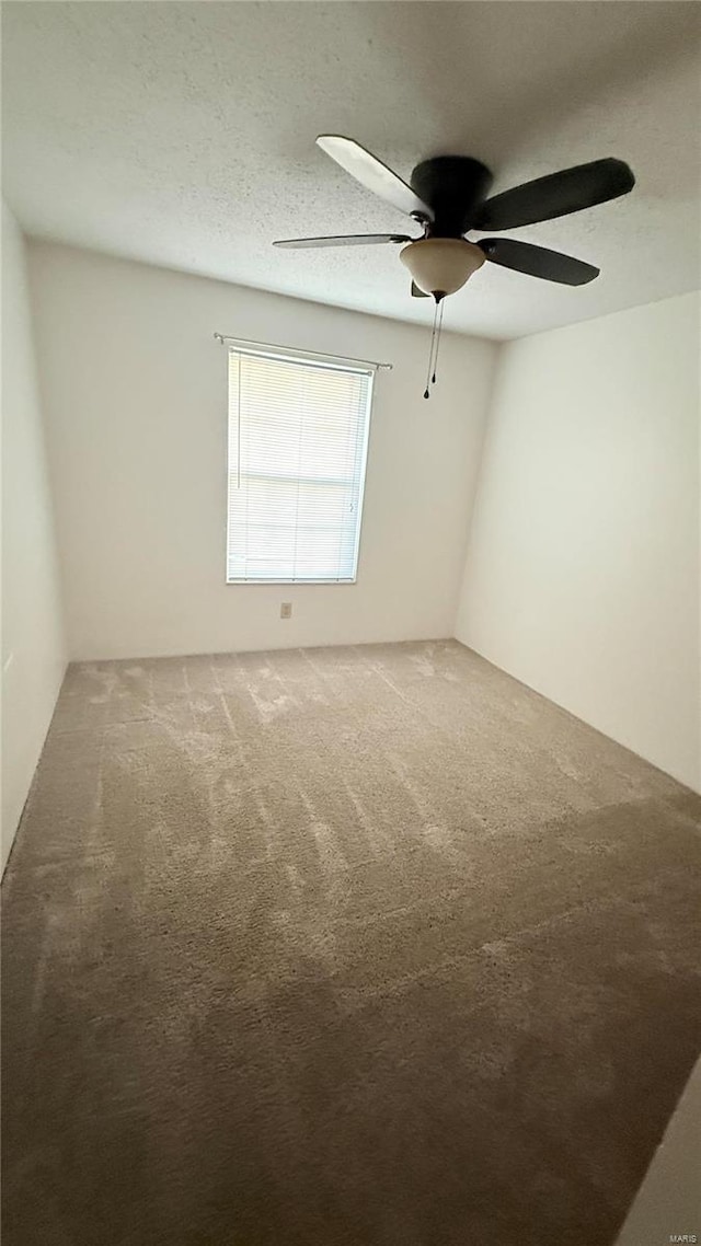 carpeted empty room featuring a ceiling fan