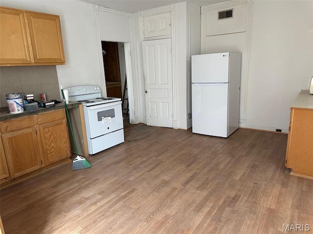 2643 Gravois Ave, Saint Louis, MO 63118 - kitchen featuring white appliances, light wood-style floors, backsplash, and dark countertops