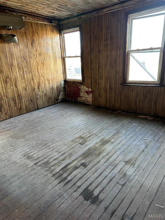 2643 Gravois Ave, Saint Louis, MO 63118 - spare room featuring hardwood / wood-style flooring and wooden walls