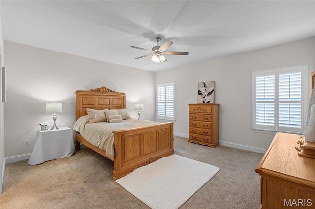 bedroom with light carpet, baseboards, and a ceiling fan