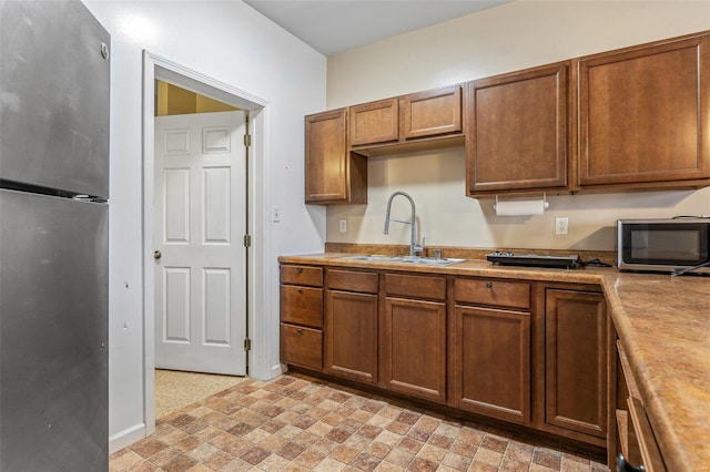 6400 Hoot Owl Ln, French Village, MO 63036 - kitchen with stainless steel appliances, a sink, light countertops, brown cabinets, and baseboards