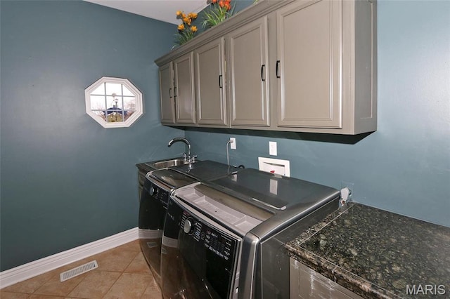 589 Wetherby Terrace Dr, Ballwin, MO 63021 - laundry area featuring cabinet space, washer and clothes dryer, light tile patterned floors, and baseboards